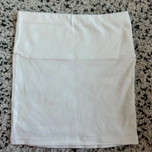 Vit tube topp från Djerf Avenue - Säljer en stilren vit tube topp från Djerf Avenue. Toppen har en enkel design och är perfekt för en minimalistisk look. Den är gjord i ett mjukt material som ger en bekväm passform.