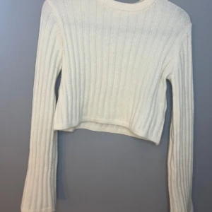 Vit ribbad croppad tröja - Säljer en stilren vit ribbad tröja från samsa COLLECTION. Tröjan är croppad och har långa ärmar, perfekt för en trendig look. Passar bra till både jeans och kjol. Perfekt för höst och vår! Sällan använd.