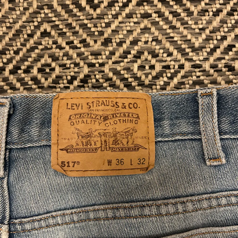Säljer ett par klassiska Levi's 517 jeans i blå denim. De har en bootcut-stil och en snygg slitning på ena benet. Perfekta för en avslappnad look. Igentliga storleken är 34/30. Farkut & Housut.