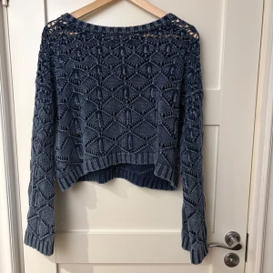 Blå stickad tröja från Zara - Säljer en blå stickad tröja från Zara med ett unikt mönster och långärmad design. Tröjan har en croppad passform och är perfekt för kyligare dagar. Den är både stilren och bekväm.