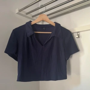 Mörkblå croppad topp med krage - Snygg mörkblå croppad topp från SHEIN med krage och v-ringning. Perfekt för en stilren look.