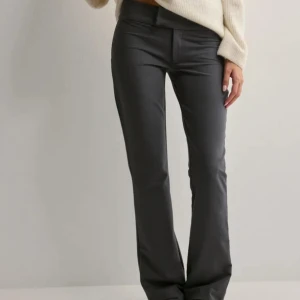 Grå utsvängda byxor från Nelly - Snygga grå kostymbyxor från Nelly i stretchigt material. De har en låg midja och en utsvängd modell. I 34 men passar 36 eftersom dom är stretchiga💕