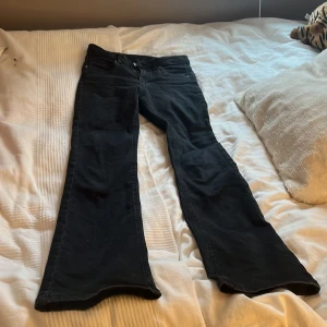 Svarta bootcut jeans - Snygga svarta bootcut jeans med dragkedja och knapp framtill. De har en klassisk femficksdesign och är perfekta för en avslappnad stil. Passar bra till både sneakers och klackar.