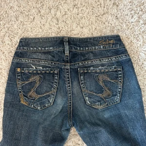 Lågmidjade bootcut jeans från Silver Jeans Co. - Snygga low waist jeans från Silver Jeans!! Säljer då de inte används längre🩷🩷 Är 175 och de är långa på mig! 36cm tvärs över midjan och 84cm innerbenslängd