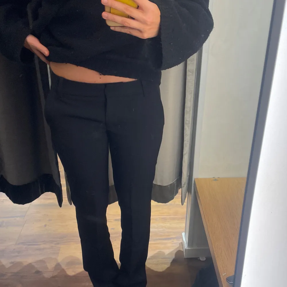 Snygga svarta kostymbyxor med låg midja och en klassisk straight passform. Perfekta för en stilren look. Byxorna har diskreta fickor och en enkel design som gör dem mångsidiga. Har gjort en egen slit så dom ska ligga snyggare på skorna🥰. Farkut & Housut.