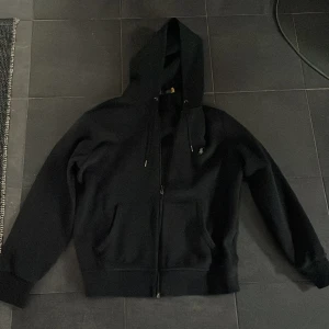 Svart hoodie från Polo Ralph Lauren - Säljer en klassisk svart hoodie från Polo Ralph Lauren. Den har en dragkedja framtill och en praktisk huva med snörning. Perfekt för en avslappnad stil. Pris kan diskuteras!