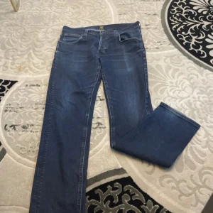 Blå jeansbyxor - Snygga blå jeansbyxor med klassisk femficksdesign och en bekväm passform. Perfekta för en avslappnad stil. De har en rak siluett och är tillverkade i ett slitstarkt denimtyg.