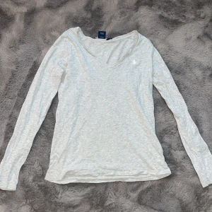 Grå tröja från Ralph Lauren - Säljer min super fina v-ringade tröja från Ralph Lauren. Tröjan är i storlek xs-s. Hör av er vid frågor