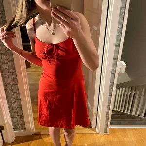 Röd klänning - Säljer den här röda klänninger i storlek 36. Den har knytdetalj både fram och bak vilken gör att banden är justerbara💕Klänningen är endast testad och har lapparna kvar. Säljer den då jag beställde hem flera klänningar och jag inte behöver alla.