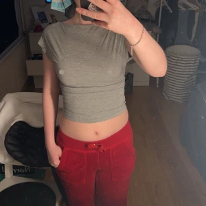 Grå croppad topp med öppen rygg - Säljer en stilren grå croppad topp med korta ärmar och öppen rygg. Perfekt för en trendig look. Passar bra till både jeans och kjol.