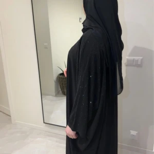 Amina abaya - 2 delat set - Exklusiv Amina Abaya – Lägsta pris!  Säljer denna lyxiga abaya från Dubai – fasta priser, inga bud!  📌 Ingår: ✔️ Abaya + svart chiffong hijab ✔️ Högkvalitativt tyg med reflekterande effekt  📏 Storlekar: 🔸 52 (132 cm) – 1 kvar 