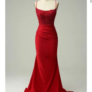 Röd långklänning med öppen rygg - Elegant röd balklänning  med smala axelband och öppen rygg. Klänningen har vackra spetsdetaljer och glittrande paljetter som ger en lyxig känsla. Säljer pga att jag hittat en annan balklänning 💕