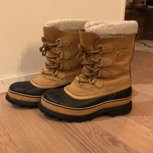 Vinterkängor CARIBOU från Sorel - Robusta och varma vinterstövlar i läder från Sorel, vattentäta. Stövlarna har snörning och en fodrad uttagbar insida för extra värme. Fint skick! 