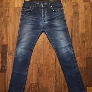 Dsquared2 jeans - slim fit - W34 L34  - Snygga blå jeans från Dsquared2 med en klassisk femficksdesign och knappgylf. Jeansen har en lätt tvättad look och är tillverkade i en bomullsblandning för extra komfort. Perfekta för en stilren vardagslook.