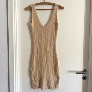 Knitted klänning - Stickad, stretchig klänning med V-neck från NA-KD! Plagget är oanvänt och i nyskick! Det är bara att skriva om du har några frågor! <3 