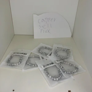 Elastiskt armband med vita och gråa stenar - Snyggt elastiskt armband med vita och gråa marmorerade stenar. Perfekt för att ge en stilren touch till din outfit. Armbandet är enkelt att ta på och av tack vare den elastiska tråden.