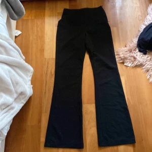 Svarta byxor från H&M - Snygga svarta kostym byxor från H&M med hög midja och bootcut-stil. Perfekta för en stilren look. Tillverkade i ett bekvämt material som ger en skön passform.