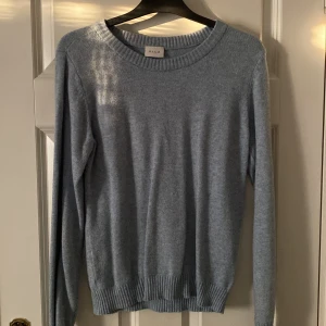 Blå tröja från VILA - Säljer en stilren blå tröja från VILA i storlek XS. Tröjan är långärmad och har en rund halsringning med ribbade kanter. 