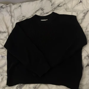 Svart ribbad tröja från Weekday - Säljer en stilren svart ribbad tröja från Weekday. Perfekt för kyligare dagar med sin mjuka och bekväma passform. Tröjan har långa ärmar och en klassisk rund halsringning. 💯