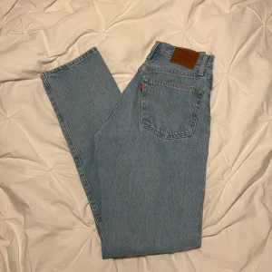 Levis 501 jeans i ljusblå denim - Klassiska Levis 501 jeans i ljusblå denim. Dessa jeans har en rak passform och är högmidjade, vilket ger en tidlös look. Perfekta för en avslappnad stil.