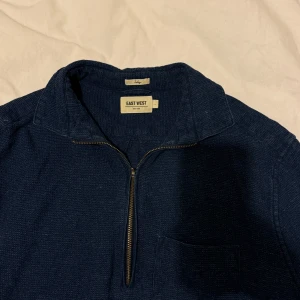 Mörkblå overshirt från East West - Snygg mörkblå overshirt från East West med dragkedja framtill och en bröstficka. Perfekt för lager-på-lager-stil. Långärmad design med klassisk krage.