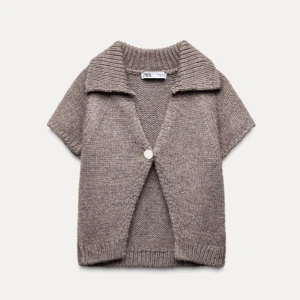 Beige stickad kofta från Zara - Säljer en mysig beige stickad kofta från Zara med korta ärmar och en stor knapp framtill.  Skriv för egna bilder!