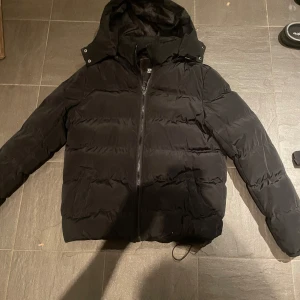 Svart urban classics jacka - Svart urban classics pufferjacka i storlek M. Den by är i ett väldigt bra skick och är knappt använd. 