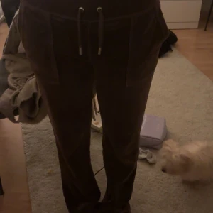 Bruna Juicy Couture byxor - Säljer ett par bruna mjukisbyxor från Juicy Couture i storlek S. normal i storleken men är själv 173 och går på dom. nytt skick, ser ut som dom är nya!