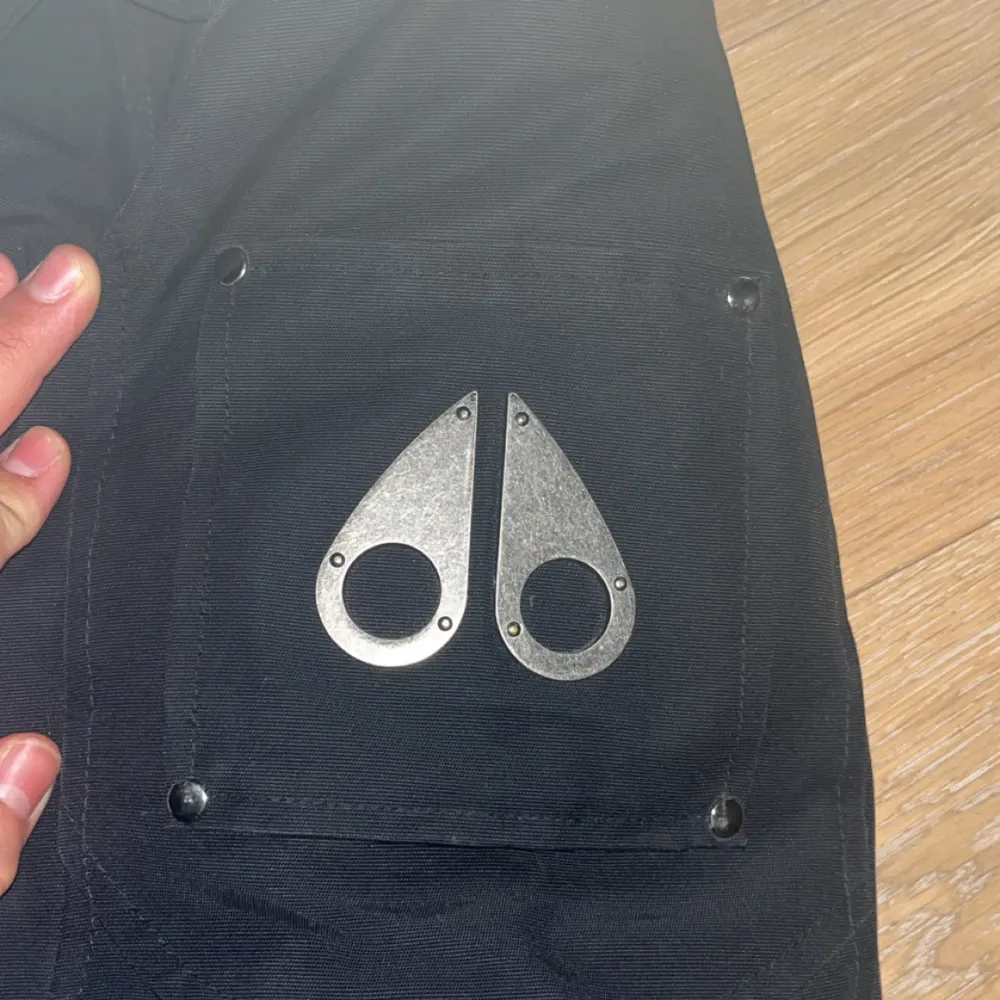Snygg svart parkajacka från Moose Knuckles med pälsdetalj på huvan. Jackan har en dragkedja framtill och praktiska fickor. Perfekt för kyliga dagar. Jackan köpt för 2 år sedan från Johnells. Dm för mer bilder pris kan diskuteras vid snabb affär. . Takit.