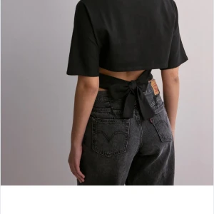 Svart topp med knytband - Anygg topp med knytning i ryggen. Populär topp från Nelly. Helt ny med prislapp kvar i storlek medium men passar mig med xs eftersom man kan knyta den där bak!💗💗