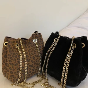 Leopard- och svart axelväska med kedja - Säljer väskan till vänster (d en i leopardmönster) super snygg med guldiga detaljer säljer då den tyvärr inte kommit till användning