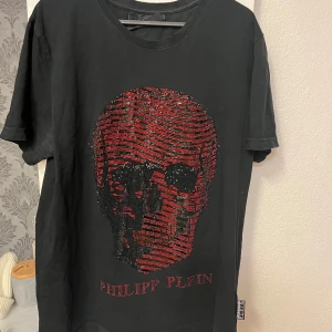 Svart t-shirt med dödskalle från Philipp Plein - Snygg svart t-shirt från Philipp Plein med en stor (äkta) Perfekt för dig som vill sticka ut med en unik design. 