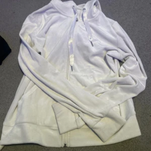 Vit hoodie med dragkedja - Säljer en vit hoodie med dragkedja och huva. Mjukt mysigt material 