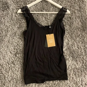 Svart spetstopp  - Säljer denna snygga spetstopp från Vero Moda. Helt oanvänd med prislapp på!💗 Stl M men passar även S