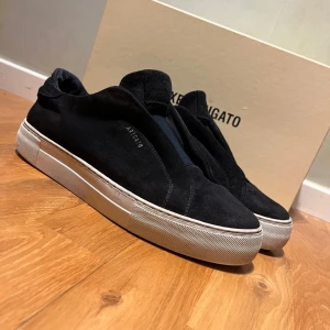 Axel arrigato laceless 360 - Snygga svarta sneakers i mocka från Axel Arigato med en stilren design. Skorna har en vit sula och är perfekta för en avslappnad stil. Byter helst men kan sälja också 