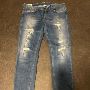 Dondup jeans - Ett par dondup jeans med slitningar som är i väldigt bra skick.