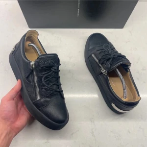 Guiseppe Zanotti skor - Snygga svarta sneakers från Guiseppe Zanotti som är nästintill helt sprillans! Storlek 40 passar större. Perfekta för en stilren look, box medföljer