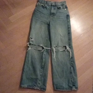 Jeans med hål - Säljer dessa vida jeans med hål och slitningar (som ska vara så). Säljer för att det inte är min stil längre. Jättefint skick, köptes typ 2023 lite osäker. Fast har använts typ 3 gånger. Dem är högmidajde. Passar mig bra som är 155. Finns såklart inte i butik längre. Skriv om du undrar något❤️
