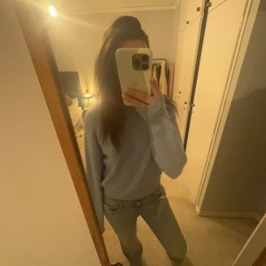 Ljusblå stickad tröja - Säljer en mysig ljusblå stickad tröja med långa ärmar och ribbade kanter. Har även tre knappar uppe längs ryggraden! ✨