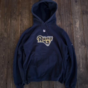 Navy vintage hoodie - Säljer en mörkblå hoodie från Reebok med Rams-logga på framsidan. Tjockt material och stor luva. Mysig tröja överlag.