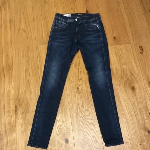 Mörkblåa Replay jeans - Snygga mörkblå jeansbyxor från Replay med en slim passform. Byxorna har en klassisk replay design på fickorna och en knappgylf. Perfekta för en stilren look.