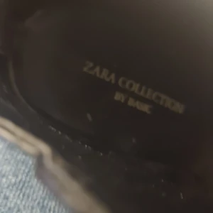 Svarta stövletter från Zara Collection - Snygga svarta stövletter från Zara Collection med spetsig tå och hög klack. Perfekta för en elegant look. Tillverkade i ett stilrent material som ger en sofistikerad touch.