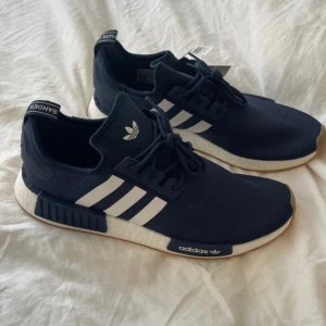 Adidas NMD R1 sneakers i marinblått - Snygga Adidas NMD sneakers i marinblått med de klassiska tre vita ränderna på sidan. Storlek 46. Säljer både här och på Vinted. Heter Jakubjjon där. 