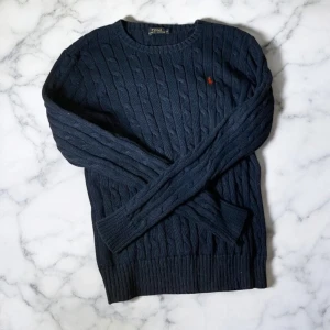 Mörkblå stickad tröja från Ralph Lauren - Hej! Säljer min kabelstickade mörkblåa Polo Ralph Lauren tröja då jag köpte fel storlek. Den är i utmärkt skick. Pris kan diskuteras vid snabb affär.