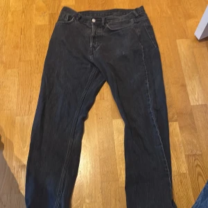 Svarta jeansbyxor - Snygga svarta jeansbyxor med klassisk design. De har en rak passform och är perfekta för en avslappnad stil. Byxorna har knappar och dragkedja framtill.