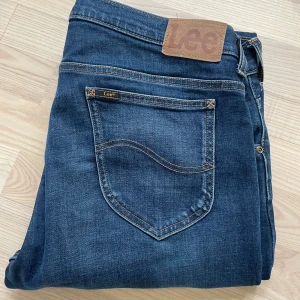 Blå Lee Jeans - Ett par blå slim fit jeans från Lee med otroligt snygg wash 🤩 Nästintill nyskick, endast använda ett par gånger! Storlek W34, L32. Hör gärna av er vid frågor mvh Ebbe 🙌