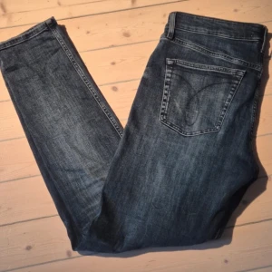 Blå jeans från Calvin Klein - Snygga blå jeans från Calvin Klein med klassisk femficksdesign. De har en rak passform och är tillverkade i ett slitstarkt denimtyg. Perfekta för en avslappnad stil.