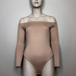 Beige/ puderrosa offshoulder bodysuit från NLY One - Beige/ puderrosa offshoulder bodysuit från NLY One. Den är ribbad och har långa ärmar. Tillverkad i mjuk polyesterblandning för en bekväm passform.