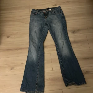 Blå bootcut jeans - Snygga blå bootcut jeans med en klassisk femficksdesign. De har en dragkedja och knapp framtill. Perfekta för en avslappnad stil.