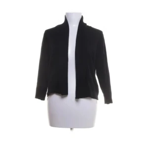 Svart jacka från Calvin Klein - Säljer en stilren svart jacka från Calvin Klein. Jackan har en öppen design utan knappar eller dragkedja och är tillverkad i en mjuk blandning av rayon, silke och nylon. Perfekt för en elegant look.